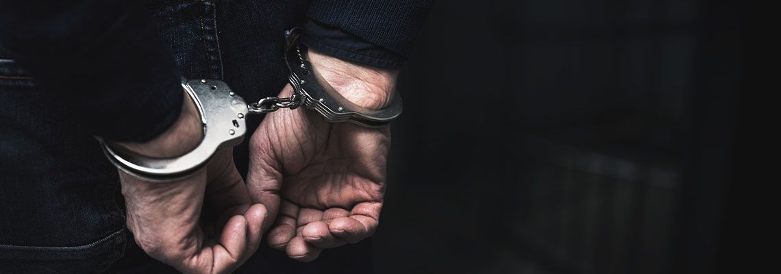 Person handcuffed with their hands behind their back