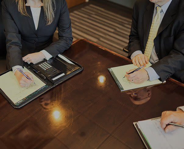 Attorneys at Beedem Law Taking Notes During Meeting