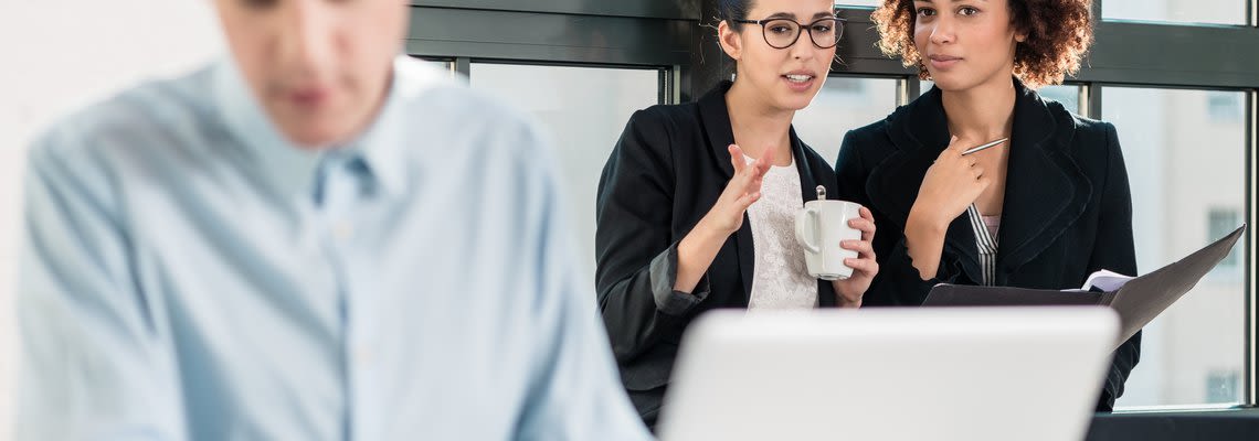 two women talking about a man behind his back