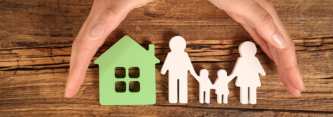 Woman holding hands near figures of house and family