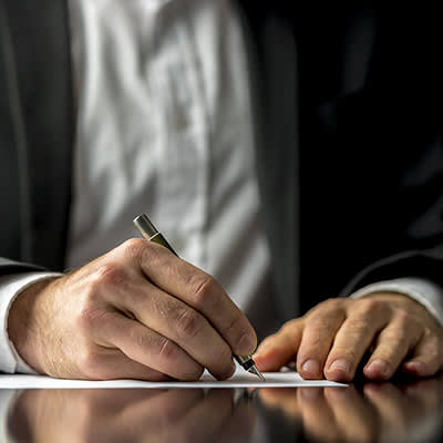 Man in suit signing document