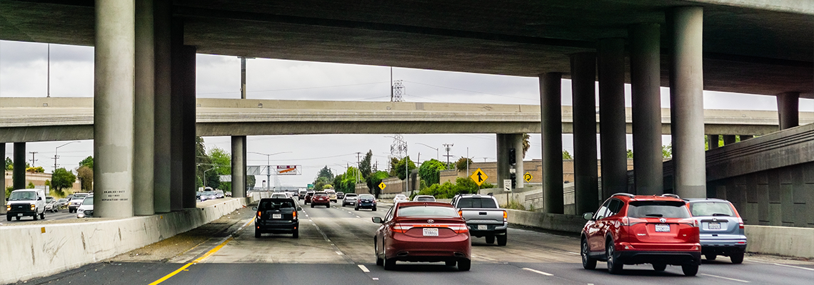 Cars driving on street underneath overpass