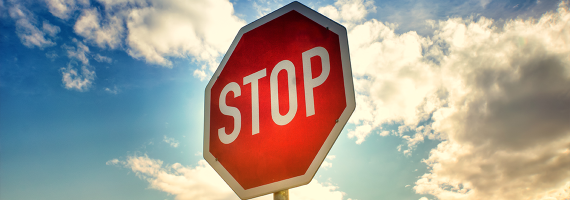Stop sign with sky and clouds behind it
