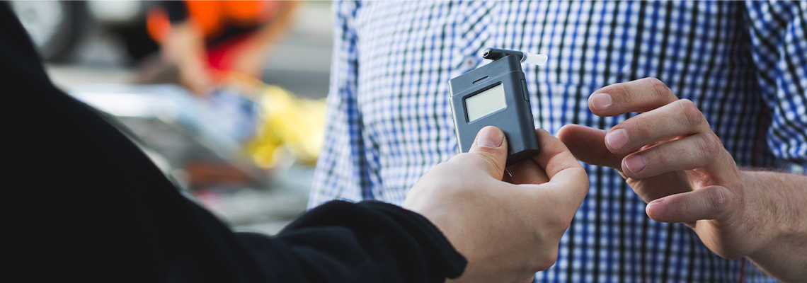 Policeman Giving a Breathalyzer to A Driver